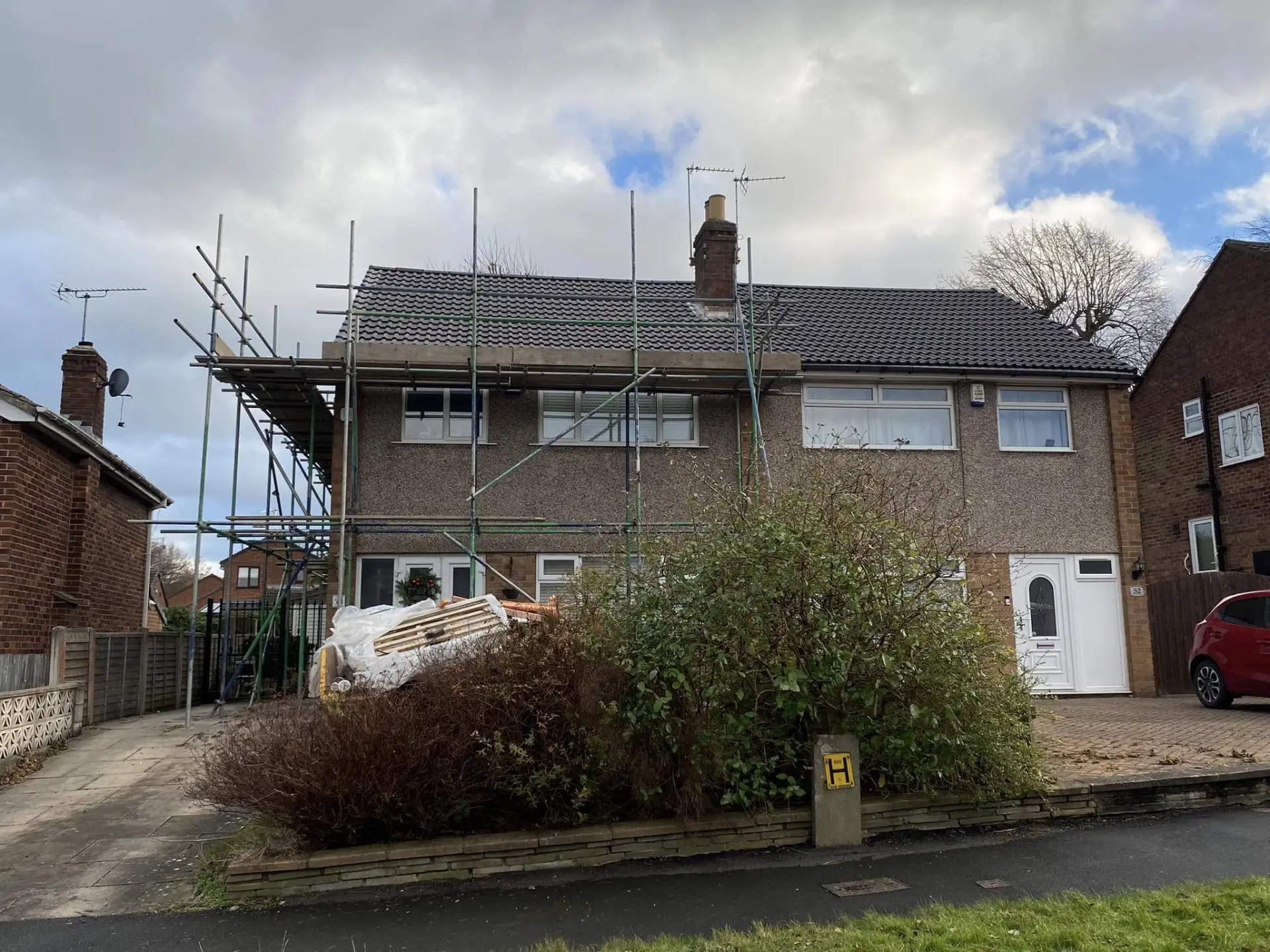 Semi-detached house with fresh tiled roof and scaffold